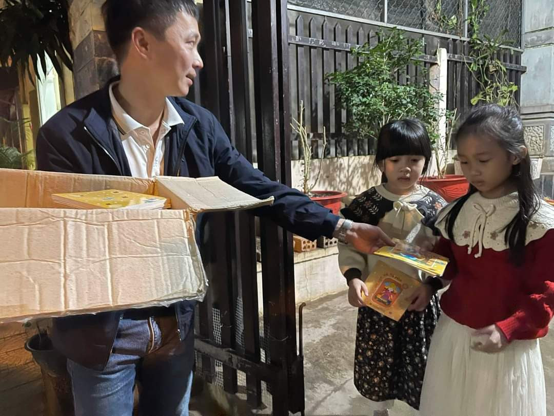 Thành viên của Chương trình Sách hóa nông thôn Quảng Trị ra đường lì xì sách trong đêm giao thừa - Ảnh: N.D.H