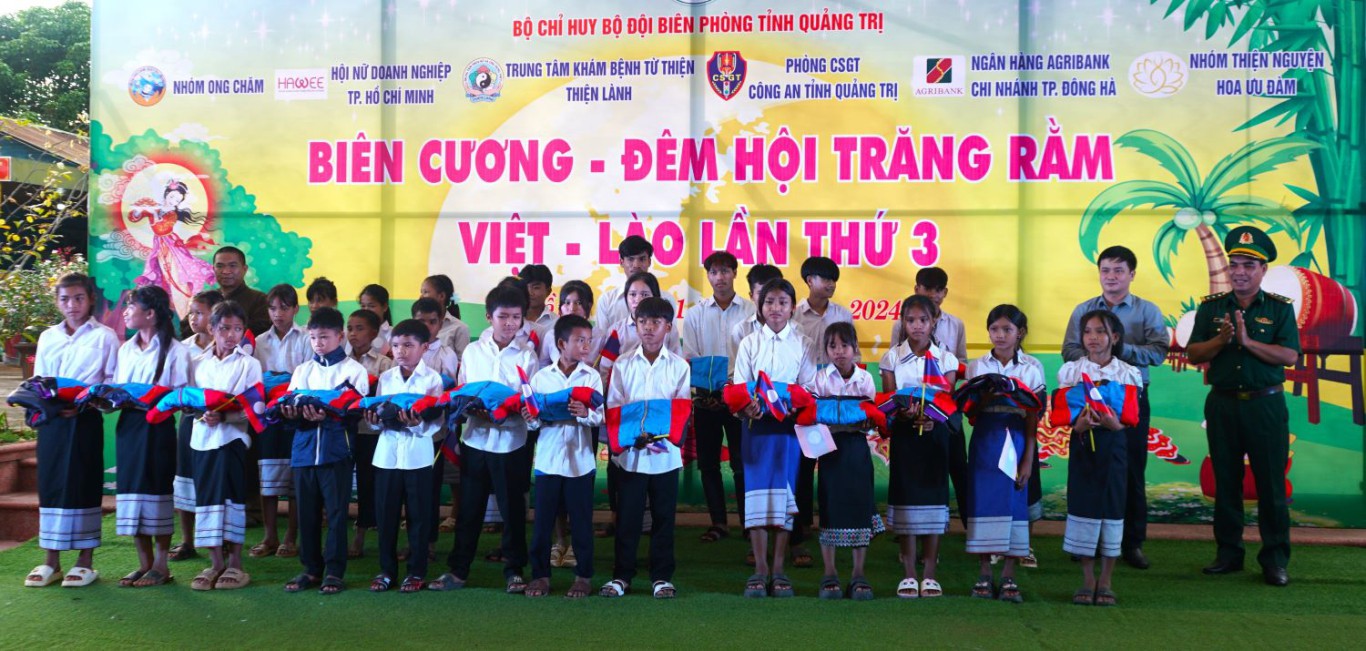 Thượng tá Hồ Phú Vinh - UVBTV - Phó Chính ủy BĐBP tỉnh tặng quà cho các cháu học sinh 5 bản ngoại biên nước bạn Lào - Ảnh: L.T